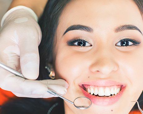 A woman getting her teeth cleaned by an dentist.