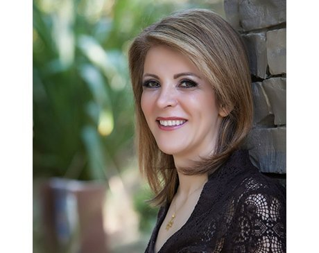 A woman with long blonde hair wearing black.